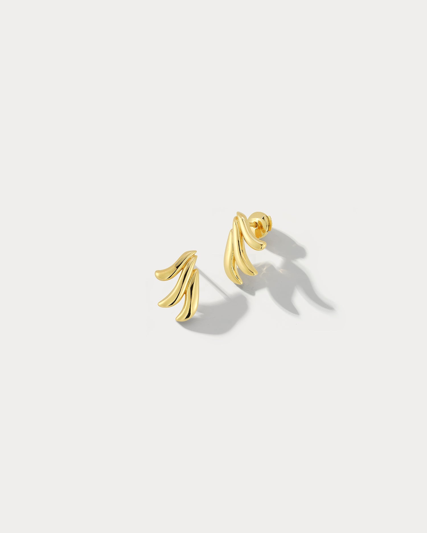 Ammrada Aspect earrings featuring sleek, modern design with geometric shapes and metallic finish, hanging elegantly on ears.