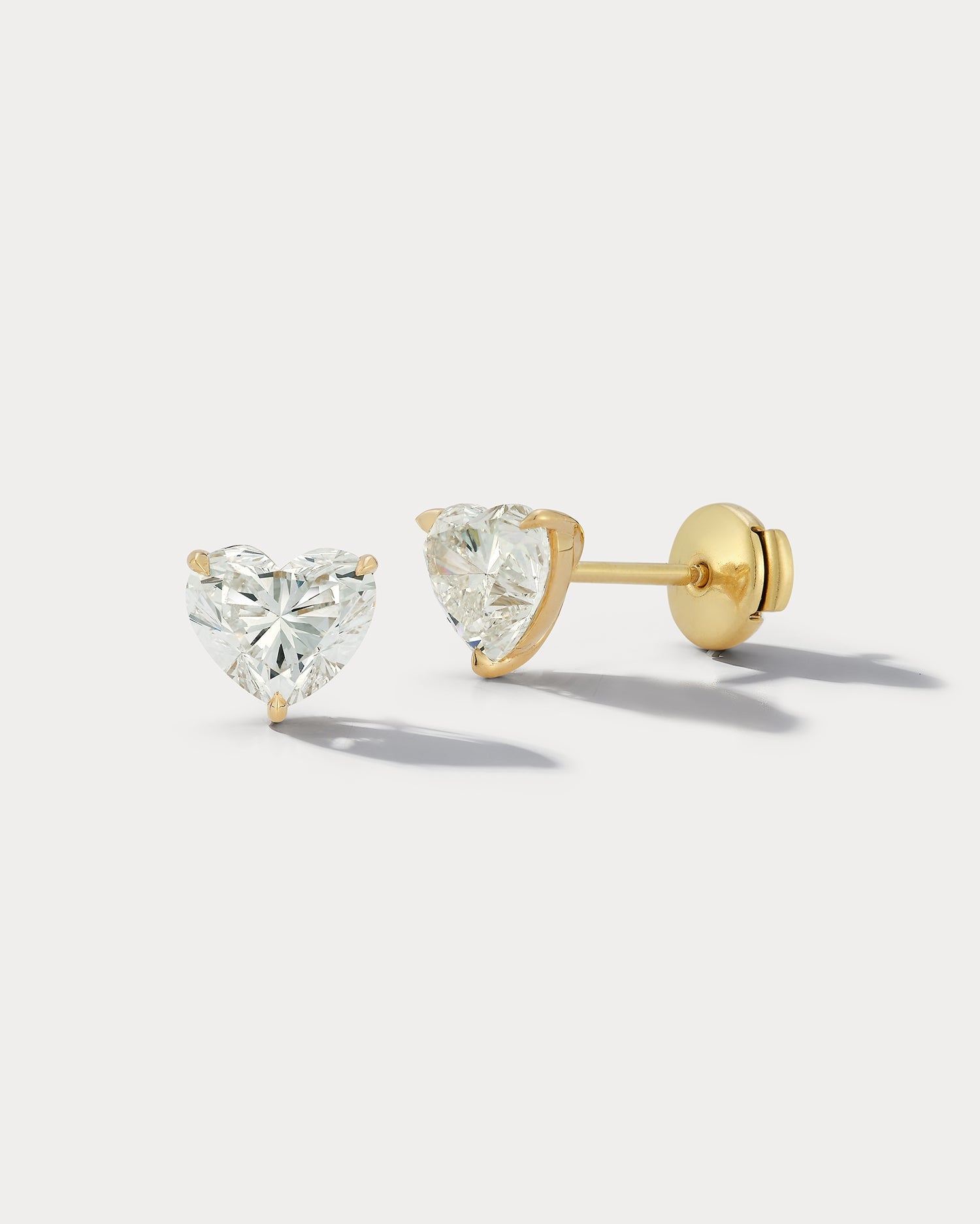 Ammrada heart-shaped diamond stud earrings with sparkling gemstones and silver setting, close-up view of the elegant jewelry.