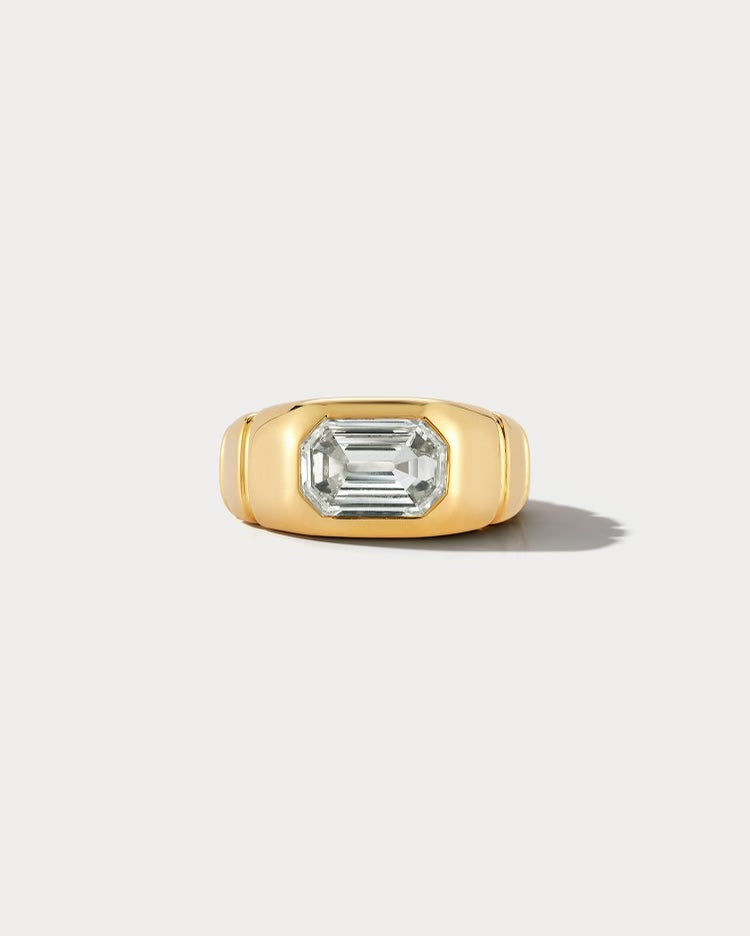 Ammrada yellow gold emerald cut pinky ring featuring a sleek design and a prominent emerald-cut gemstone on a white background.