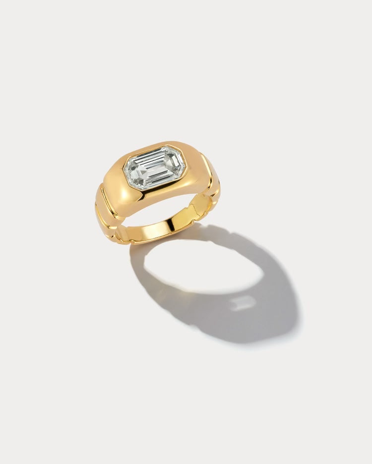 Ammrada yellow gold emerald cut pinky ring with a sleek design and polished finish, showcasing a modern and elegant jewelry piece.