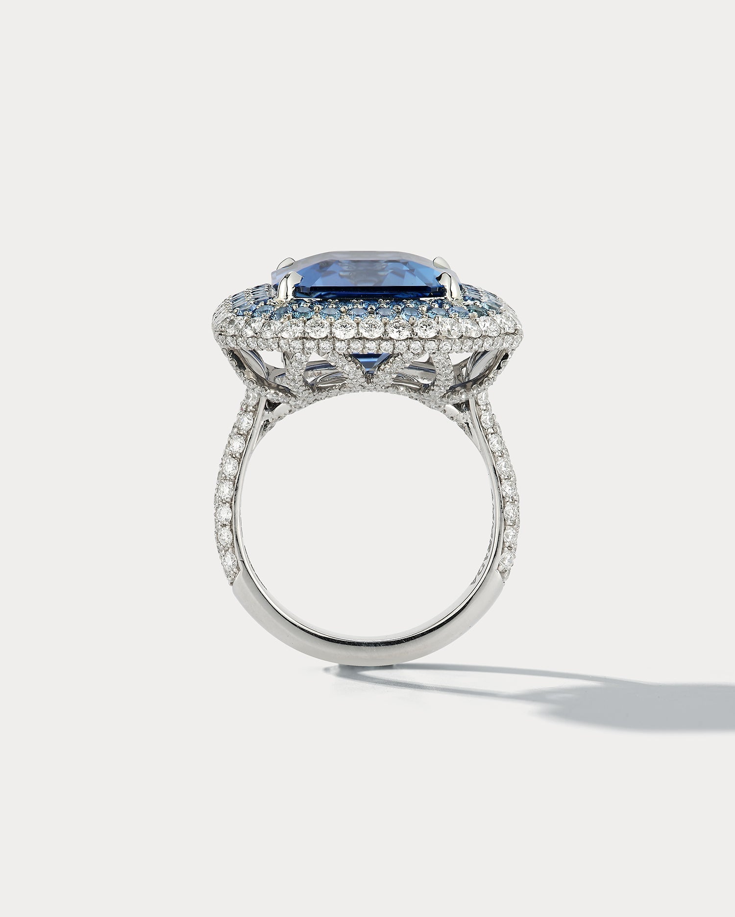 Ammrada 12ct emerald-cut sapphire ring featuring a large, vibrant blue sapphire gemstone set in a sleek band.