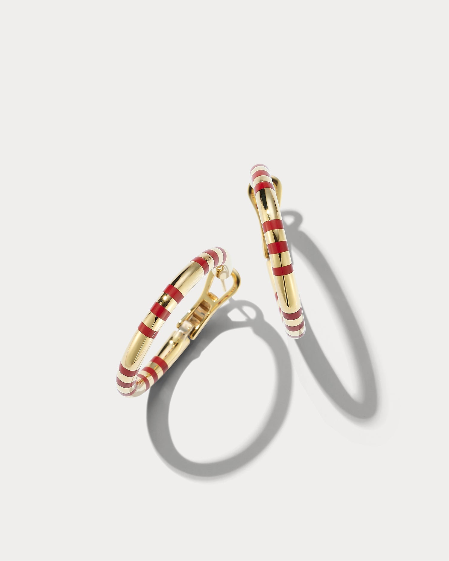 Ammrada 18K yellow gold and Texas red ceramic earring with a sleek, modern design on a plain background.