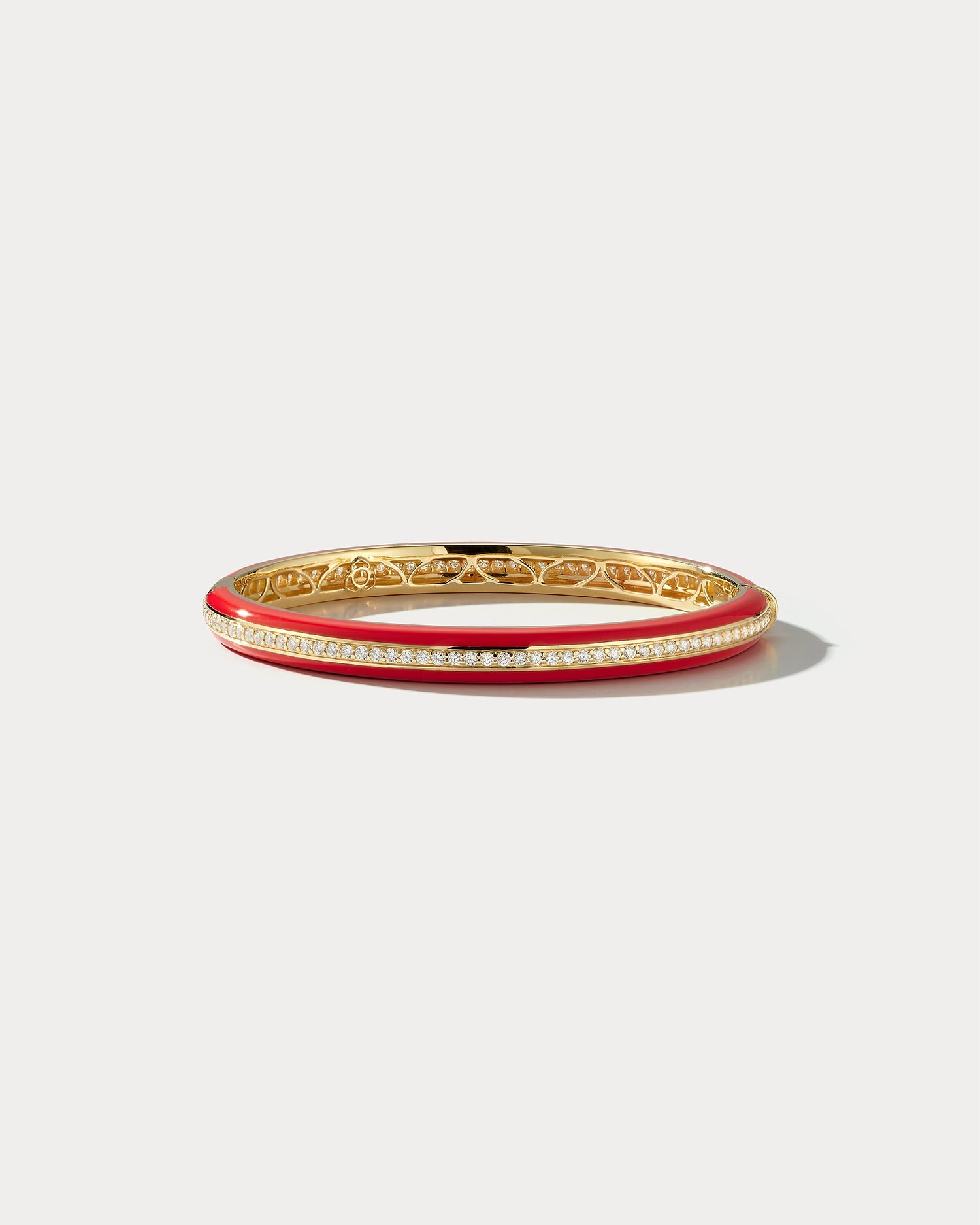 Red ceramic and yellow gold bangle with diamond accents from Ammrada, showcasing a stylish jewelry piece with intricate design.