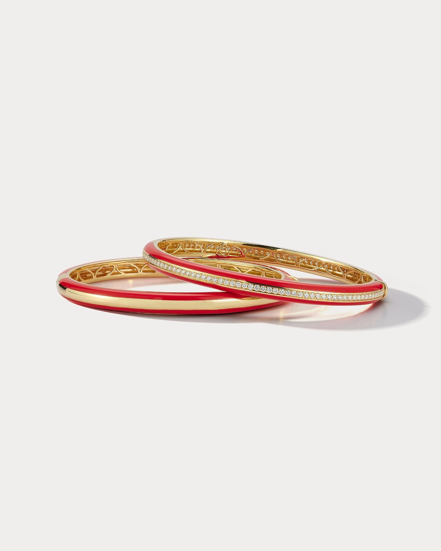 Red ceramic bangle by Ammrada with yellow gold and diamond accents, showcasing a stylish and luxurious jewelry piece.