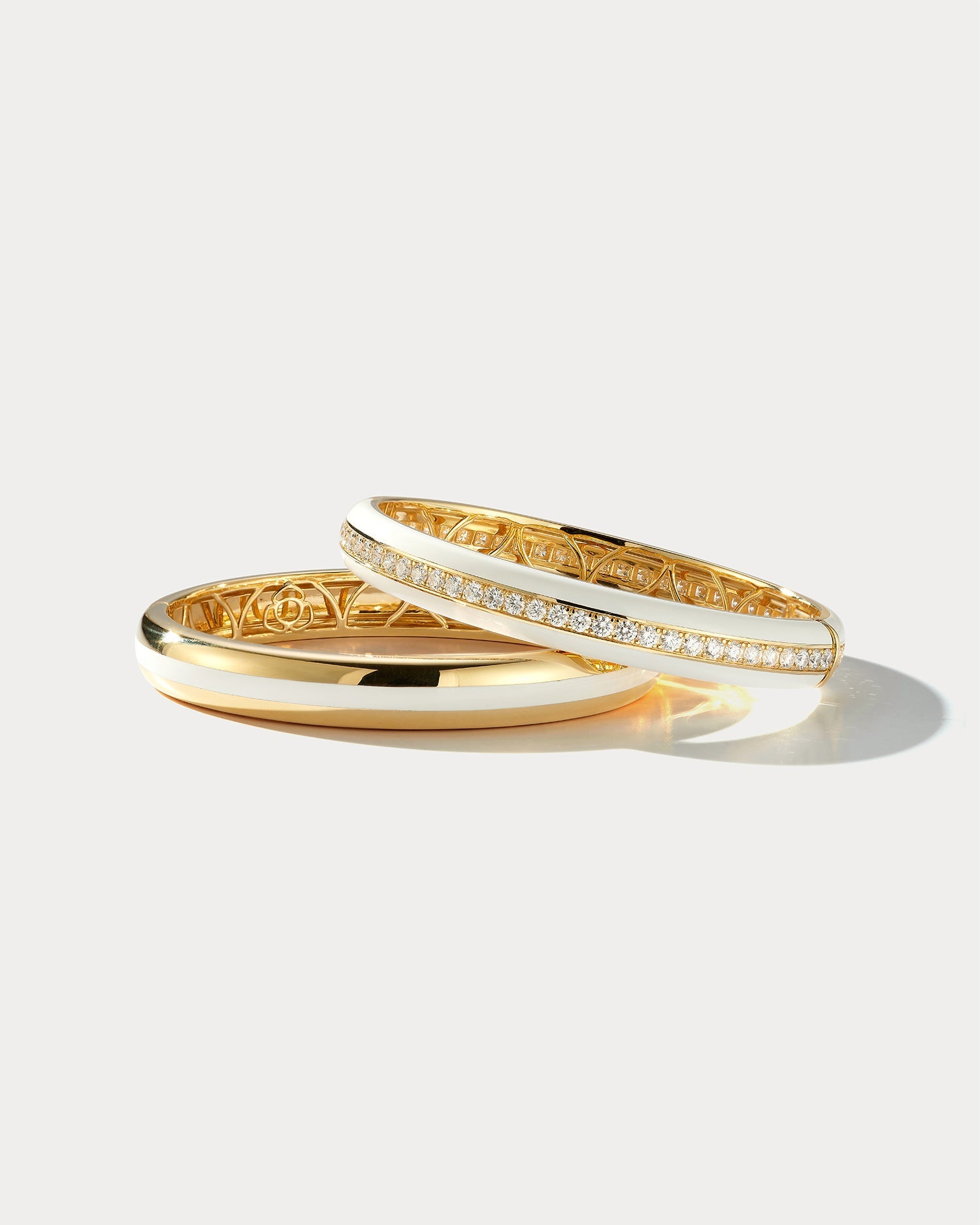 Wide white ceramic and yellow gold bangle by Ammrada, showcasing a smooth, polished surface and elegant design.