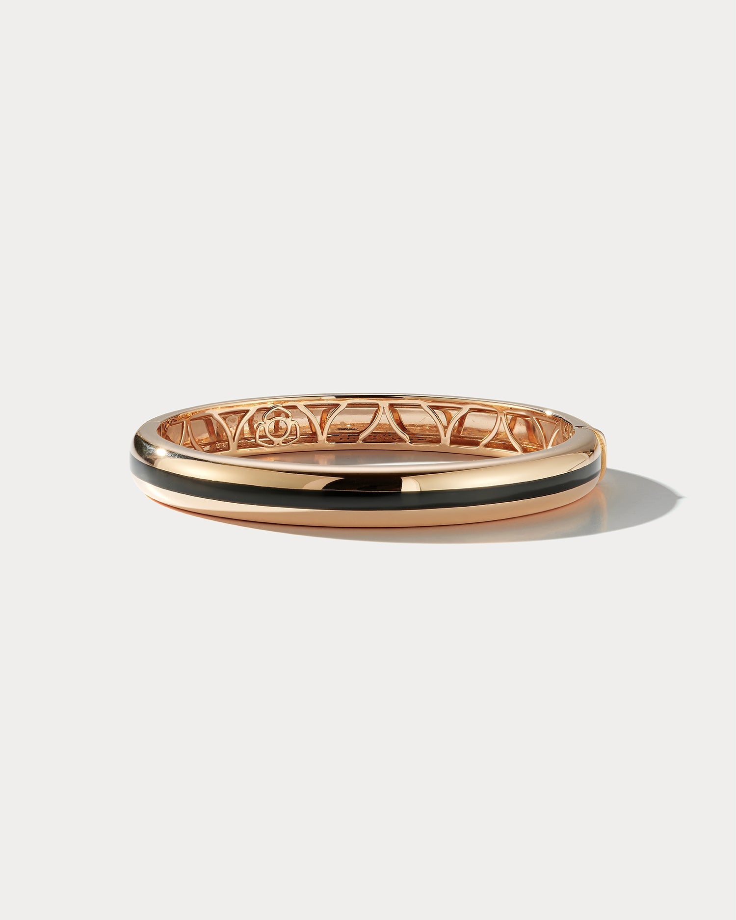 Wide black ceramic and 18k rose gold bangle from Ammrada, showcasing sleek design and luxurious materials.