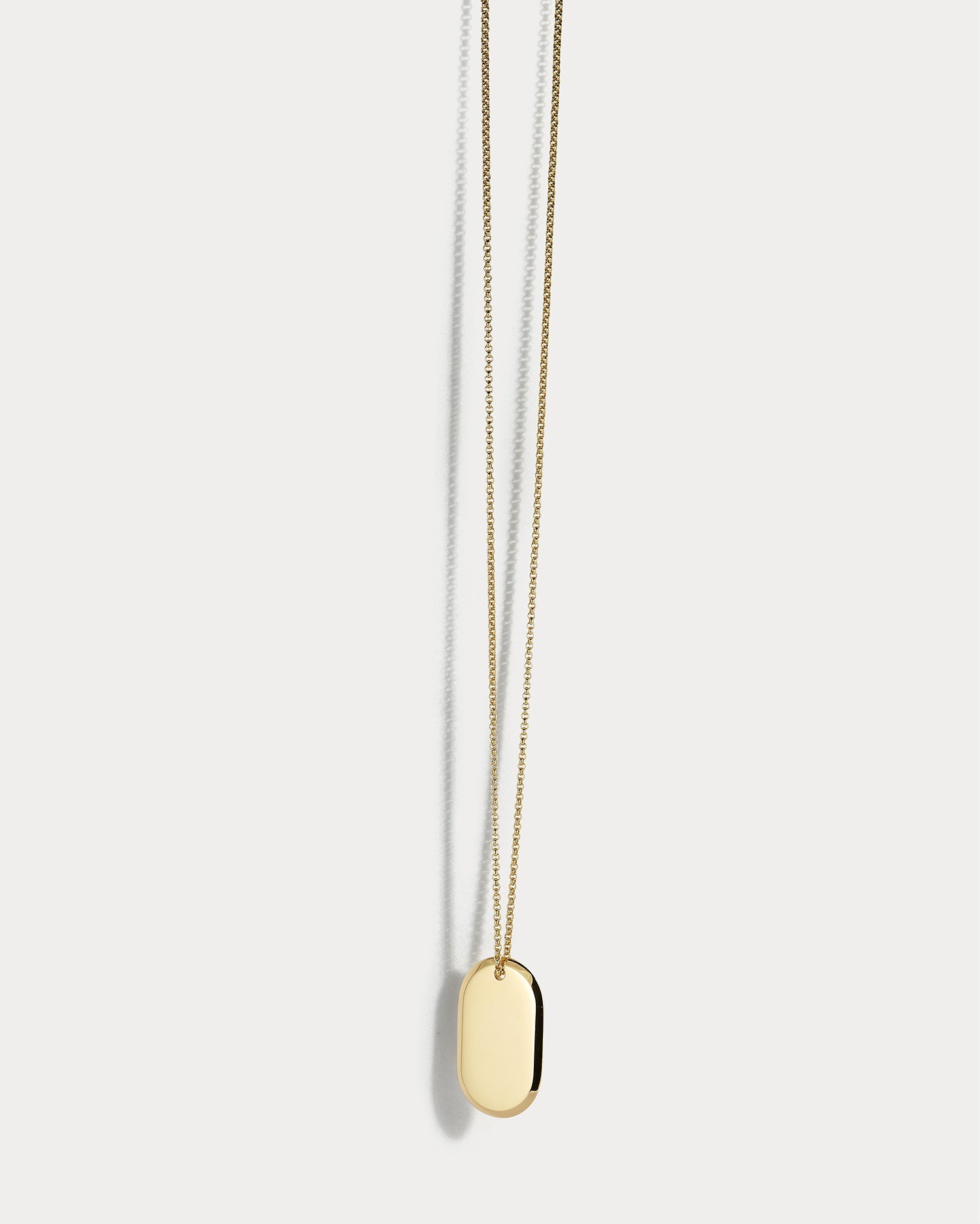 18k yellow gold dog tag from Ammrada with polished finish and engraved details.