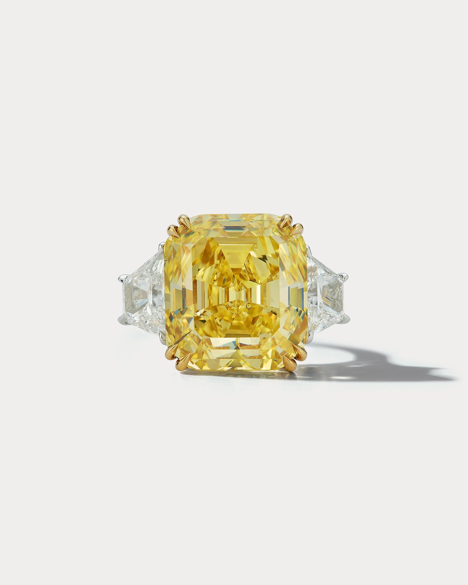 Ammrada 14.36 FIY emerald-cut center stone three-stone ring featuring a sparkling emerald-cut gemstone and elegant band design.
