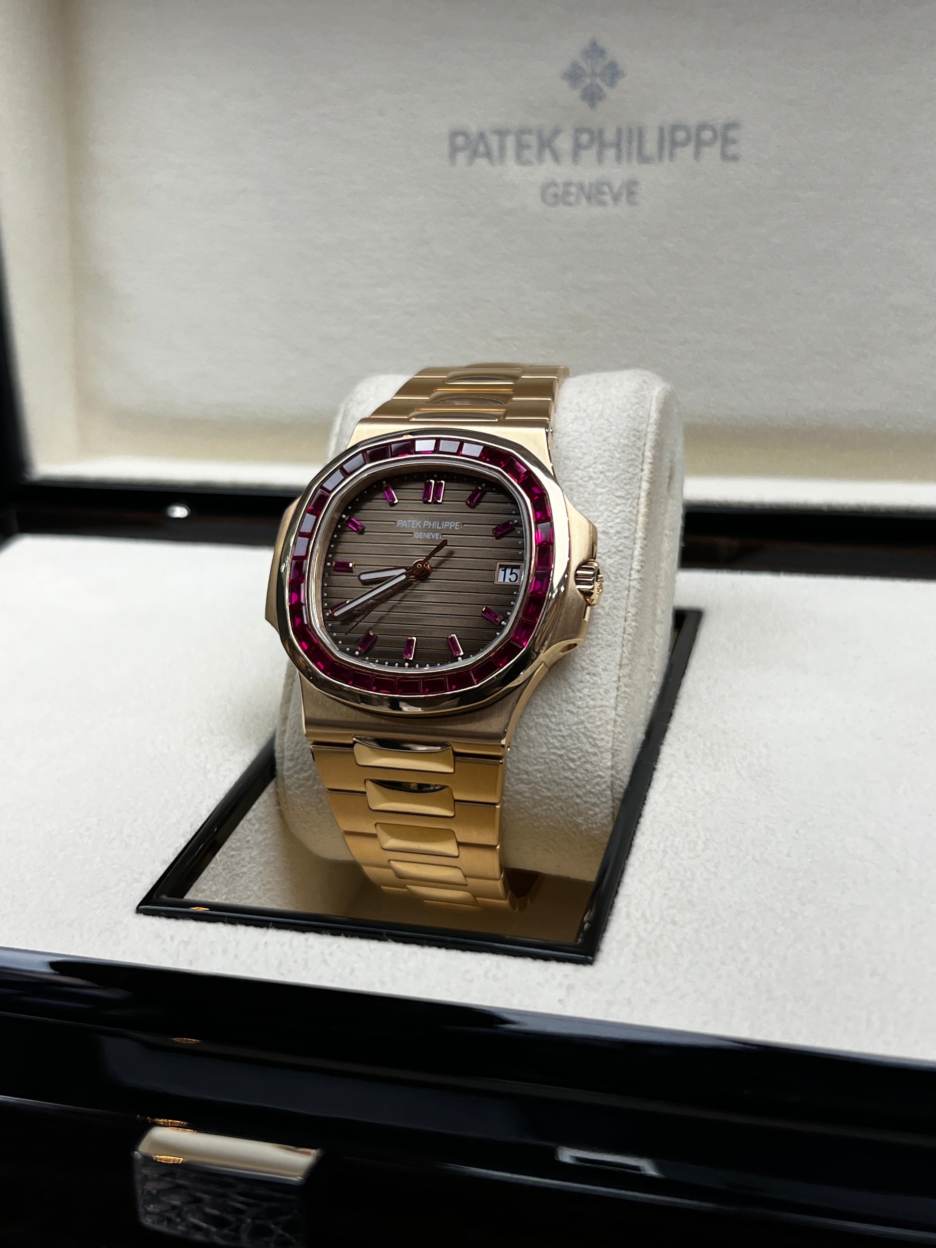 Patek Philippe Nautilus 5723/112R-001 luxury watch with a ruby dial, gold case, and stainless steel bracelet.