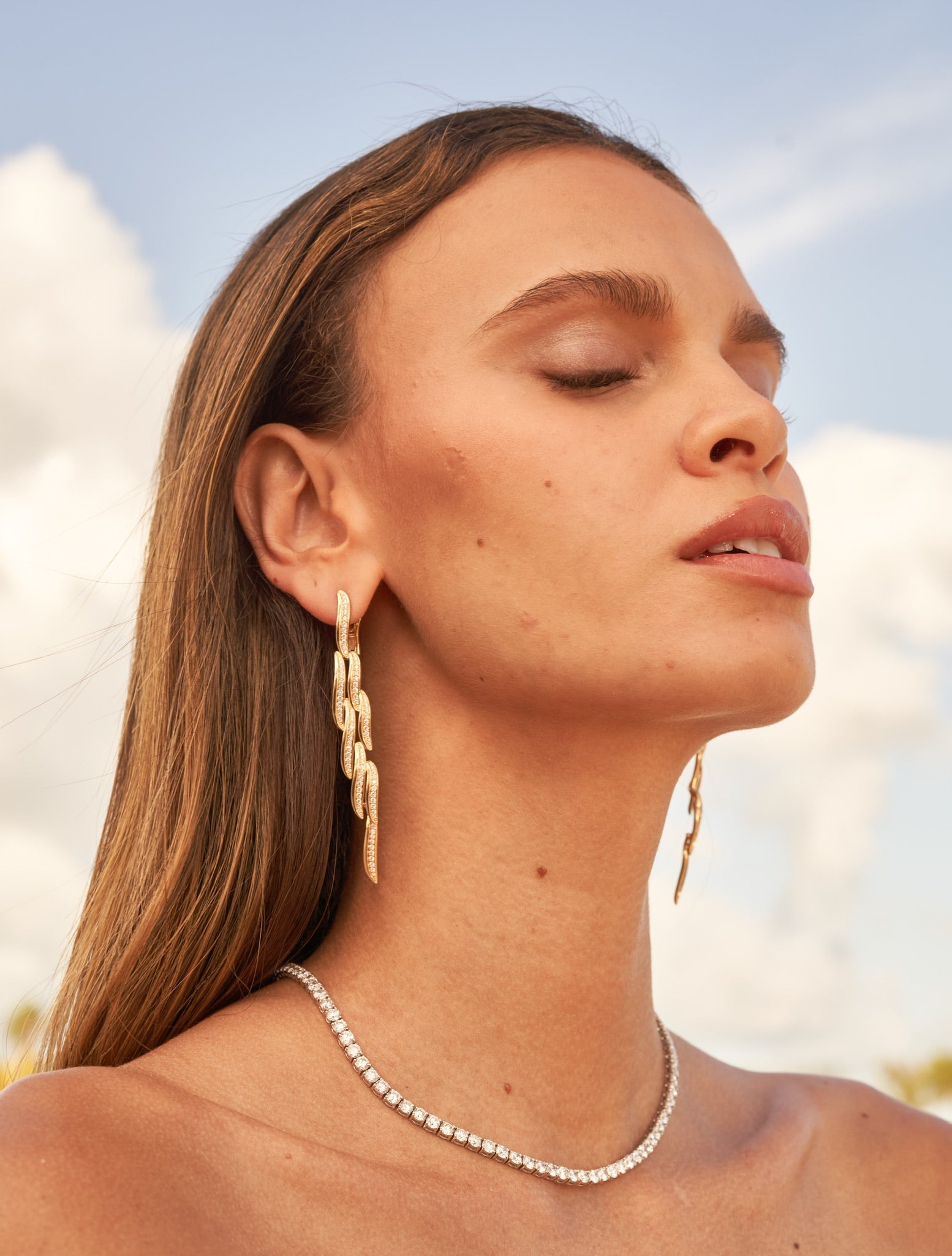 Ammrada Drop Wave earring featuring a sleek, wave-shaped design in shiny metal, displayed on a neutral background.